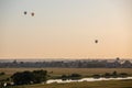 Colorful hot air balloons soar in the sky at dusk or dawn. Flight over the fog at sunrise or sunset with beautiful sky Royalty Free Stock Photo