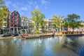 Colorful houseboats line the canal in front of colorful Dutch homes on a sunny day in early autumn in Amsterdam, Netherlands Royalty Free Stock Photo