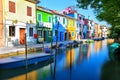 Colorful houses along a canal embankment on Burano island