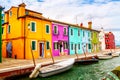 Colorful houses in Burano near Venice, Italy with boats and beautiful blue sky in summer. Famous tourist attraction in Venice