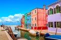 Colorful houses in Burano near Venice, Italy with boats and beautiful blue sky in summer. Famous tourist attraction in Venice.