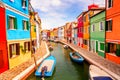 Colorful houses in Burano near Venice, Italy with boats, canal and tourists. Famous tourist attraction in Venice Royalty Free Stock Photo