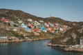 Colorful houses dot the hillsides of the fishing town of Kangaamiut, West Greenland. Icebergs from Kangia glacier in Royalty Free Stock Photo