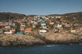 Colorful houses dot the hillsides of the fishing town of Kangaamiut, West Greenland. Icebergs from Kangia glacier in Royalty Free Stock Photo