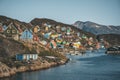 Colorful houses dot the hillsides of the fishing town of Kangaamiut, West Greenland. Icebergs from Kangia glacier in Royalty Free Stock Photo