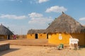 Colorful huts in Rajsathani village, Jaisalmer, India. Blue sky and white clouds background
