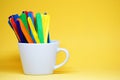 Colorful Ice cream stick on the white cup isolated with yellow pastel background -  Decorate Back to school concept with copy spac Royalty Free Stock Photo
