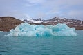 Colorful Iceberg Floating by Barren Arctic Shores