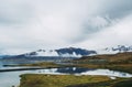 Colorful Icelandic landscapes under gray heavy sky.