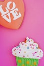 Colorful icing cookie in cupcake shape on pink background Royalty Free Stock Photo