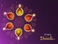 Colorful illuminated oil lamp diya on purple rangoli background.