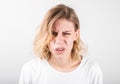 Colorful image closeup of blonde woman expressing misunderstanding isolated over gray background