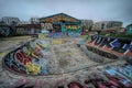 Colorful impression on a skateboard park with dense grafitti against an urban background