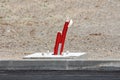 Colorful industrial plastic insulation pipes sticking out of concrete foundation for tall street light next to paved road