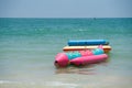 Colorful inflatable boats for playful beach sport close to seashore line, anchored at tropical sea, close up photo