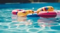 Colorful inflatable rings floating in swimming pool, shallow depth of field