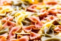 Colorful italian pasta farfalle tricolore abstract backdrop.