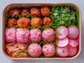 Colorful Japanese Bento Box with Rice Balls, Meatballs, Fresh Vegetables and Salad on White Background, Healthy Meal Concept