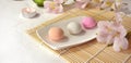 Colorful japanese dessert mochi with flowers on bamboo mat. Royalty Free Stock Photo