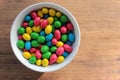 Colorful jelly beans candies in a bowl on wooden background. Sweet holiday treats for kids