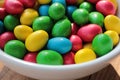 Colorful jelly beans candies in a bowl on wooden background. Sweet holiday treats for kids