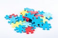 Colorful jigsaw puzzle pieces on a white background. The puzzle pieces are blue, red, and yellow in color and are scattered and