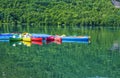 Colorful kayak boats resting on the lake in a nautical school about to slip from Huesca Spain