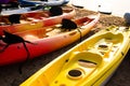 Colorful kayaks on the beach sand for tourist rent. Surfing boards on stand during summer season Royalty Free Stock Photo