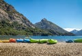 Colorful Kayaks in a lake surrounded by mountains at Bahia Lopez in Circuito Chico - Bariloche, Patagonia, Argentina Royalty Free Stock Photo