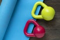 Colorful kettlebell and blue yoga mat on wooden table, fitness healthy and sport concept Royalty Free Stock Photo