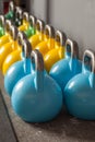 Colorful kettlebells in a row in a gym