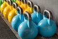 Colorful kettlebells in a row in a gym - focus on the front kett