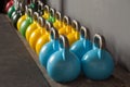 Colorful kettlebells in a row in a gym