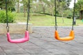 Colorful kids playground in public park, set of modern chain swings. Royalty Free Stock Photo