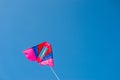 Colorful kite flying against blue sky background Royalty Free Stock Photo