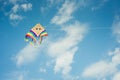 Colorful kite flying against the blue sky with clouds Royalty Free Stock Photo