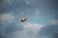 Colorful kite flying in the blue cloudy sky - a cool picture for backgrounds and wallpapers Royalty Free Stock Photo