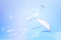 Colorful kite flying in the blue sky through the clouds Royalty Free Stock Photo