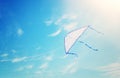 Colorful kite flying in the blue sky through the clouds Royalty Free Stock Photo