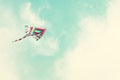 Colorful kite flying in the blue sky through the clouds. Royalty Free Stock Photo