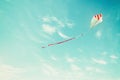 Colorful kite flying in the blue sky through the clouds. Royalty Free Stock Photo