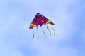 Colorful kite flying in blue sky with clouds. Royalty Free Stock Photo