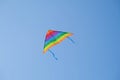 Colorful kite with flying tail in the blue sky on a hot summer day Royalty Free Stock Photo