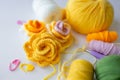 Colorful knit flowers with yarn and crochet hooks on white surface Royalty Free Stock Photo