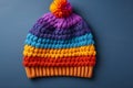 A colorful knitted hat, with a on a blue background.