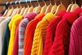 Colorful knitted women\'s sweaters on hangers in clothing store