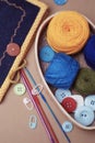 Colorful Knitting Coil kein Yarns and Crochet tools with Buttons on Beige Background. Vertical Image. Handmade Tools and Accesorie