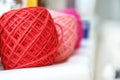 Colorful knitting yarn balls and needles on white table against blurred background. Close up of multi colored woolen balls Royalty Free Stock Photo