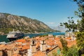 Colorful landscape with orange roofs of old town, boats and big cruise ship in marina bay, sea, mountains Royalty Free Stock Photo