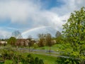 Colorful landscape with a rainbow over the trees, a small village view Royalty Free Stock Photo
